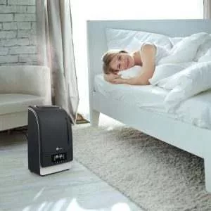 mujer en la cama contenta con el humidificador