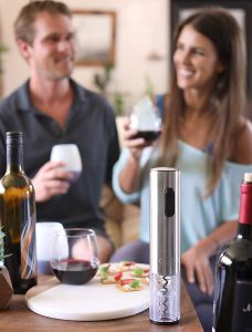 pareja disfrutando de un vino abierto con sacacorchos automatico