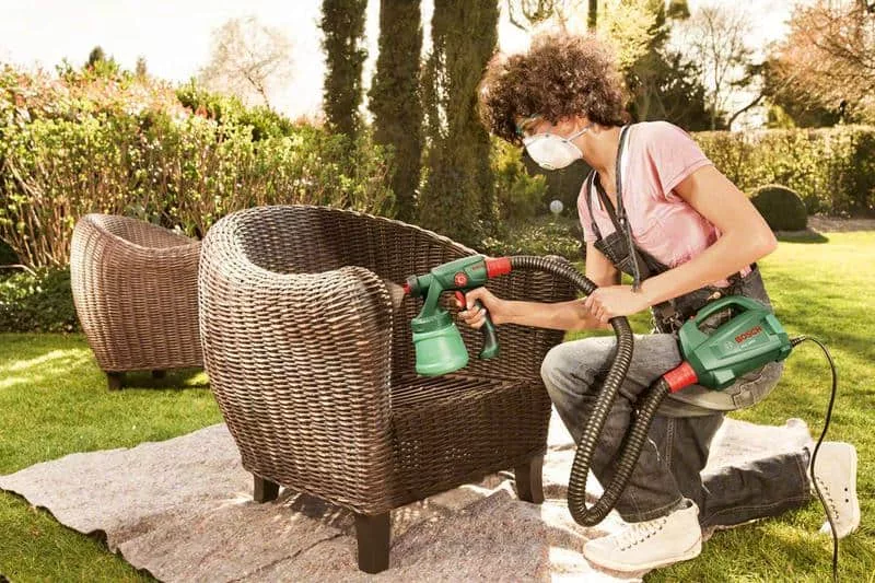 chica pintando una silla de exterior