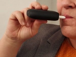 mujer fumando con un calentador de tabaco