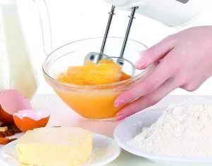 mano batiendo huevos con batidora de varillas